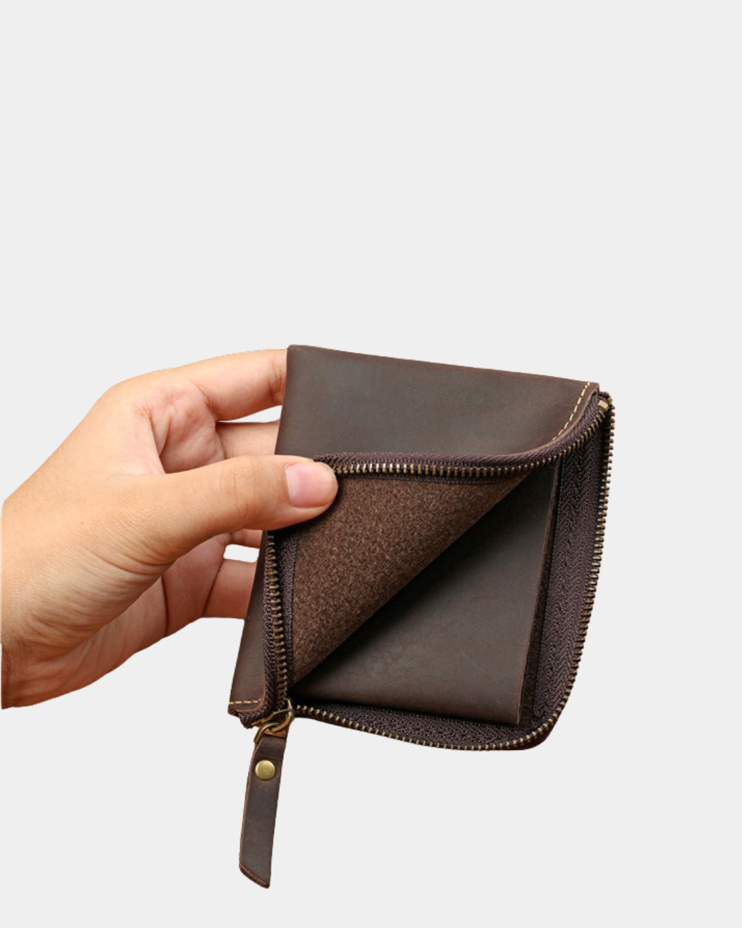 Hand holding a compact brown genuine cowhide leather wallet with a secure full zip-around closure.