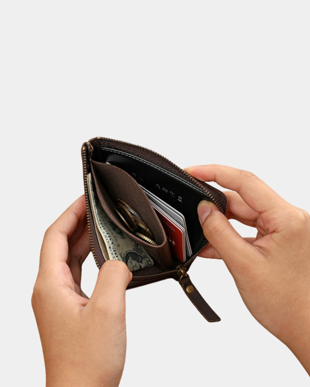 Hands holding a brown genuine leather wallet with a zip-around closure, showing interior card slots and a coin pocket.