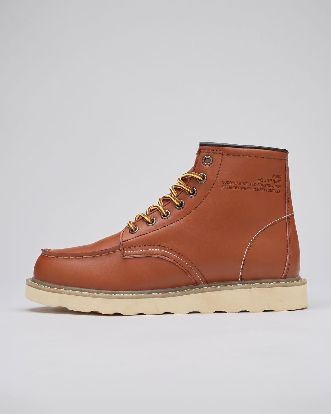 A classic cognac leather lace-up boot with gold laces and a thick beige sole, shown in a side profile on a light gray background.