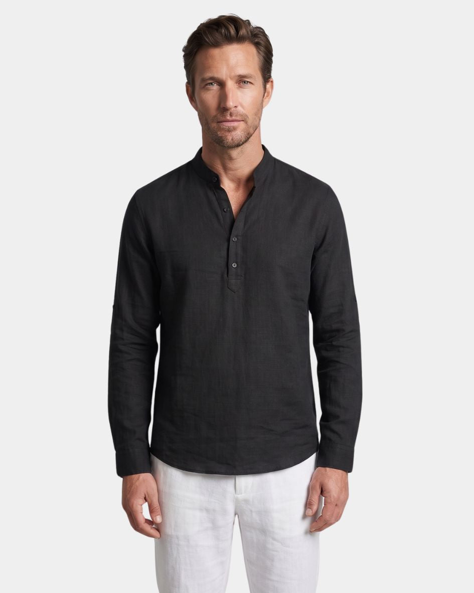 Man wearing a black long-sleeve henley shirt and white pants on a light gray background