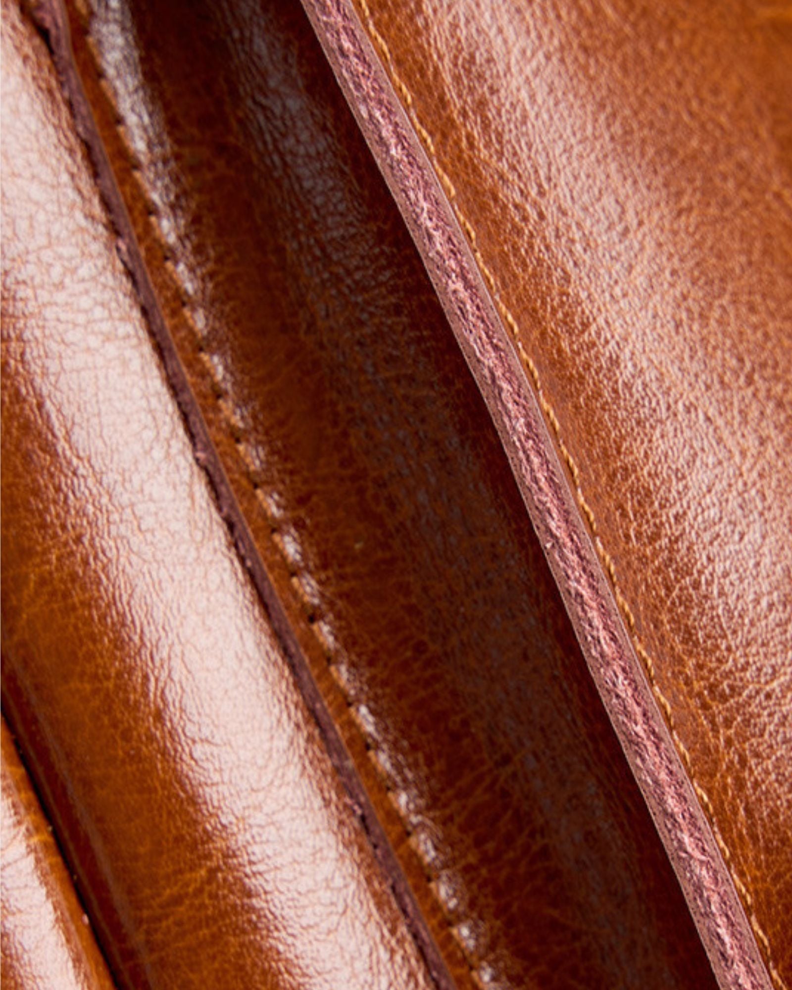 Close-up of Cambridge brown leather backpack showing contrast stitching detail