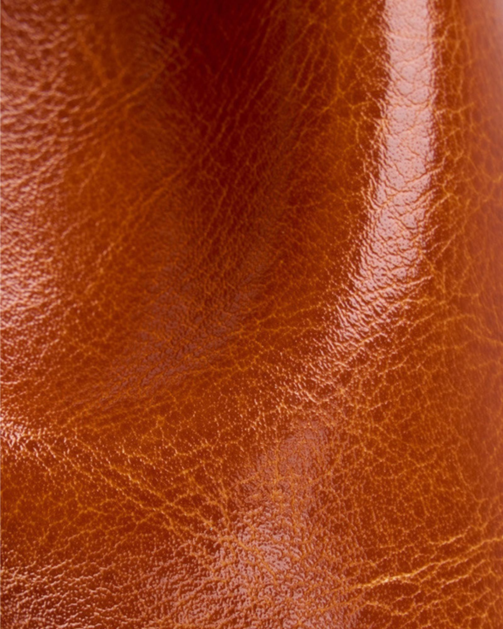 Close-up of Cambridge brown leather backpack surface showing natural grain texture