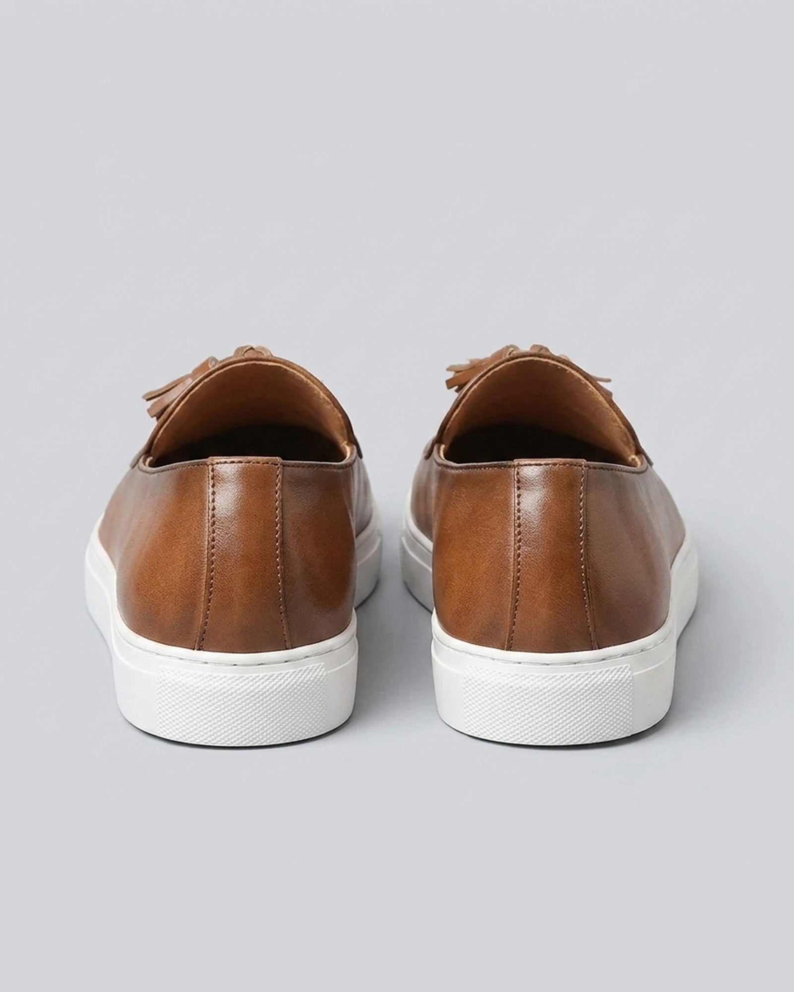 Rear view of Capri men's cognac leather tassel loafers with white cupsole