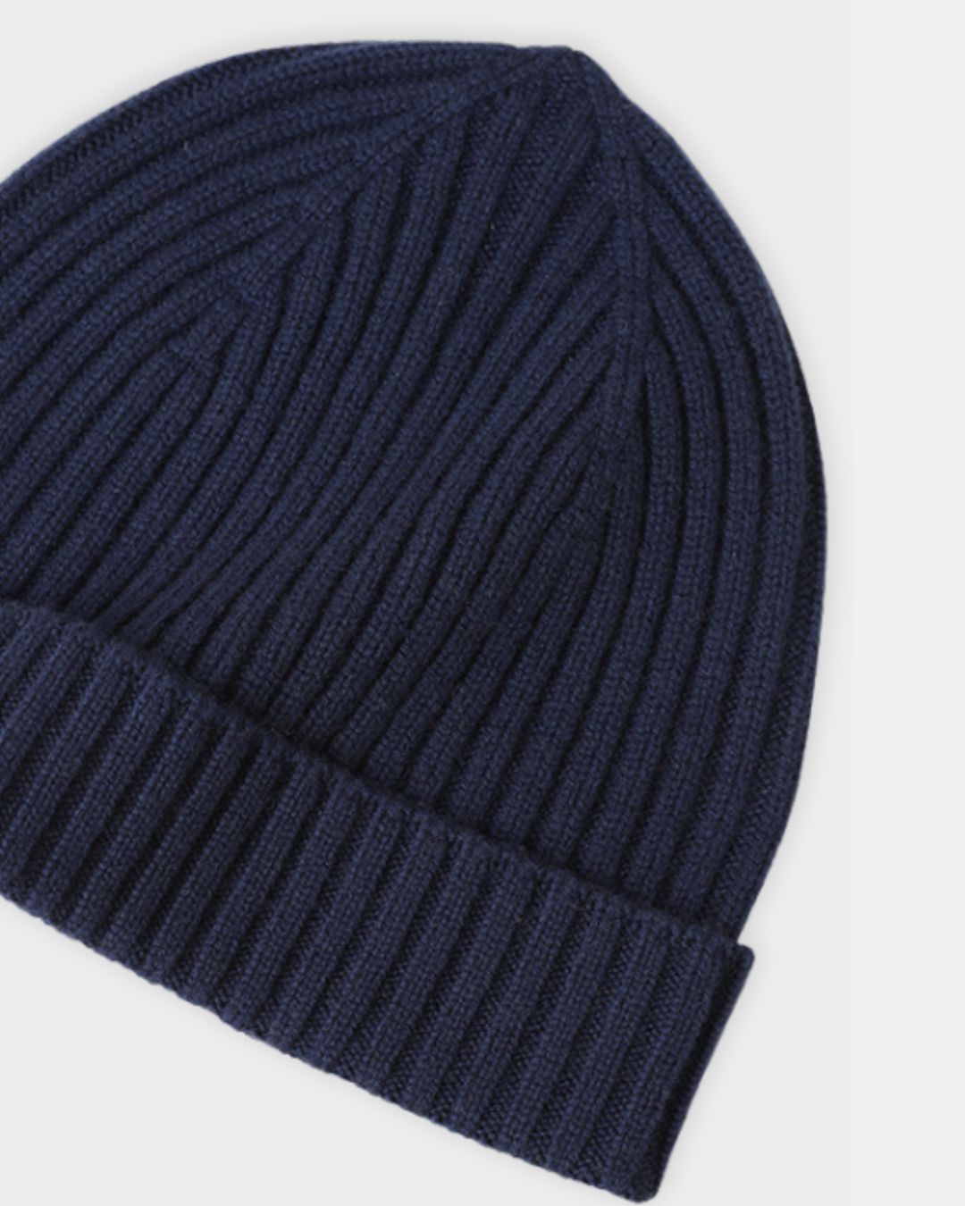 Navy blue cashmere beanie with a classic ribbed knit texture and a folded cuff for winter warmth.