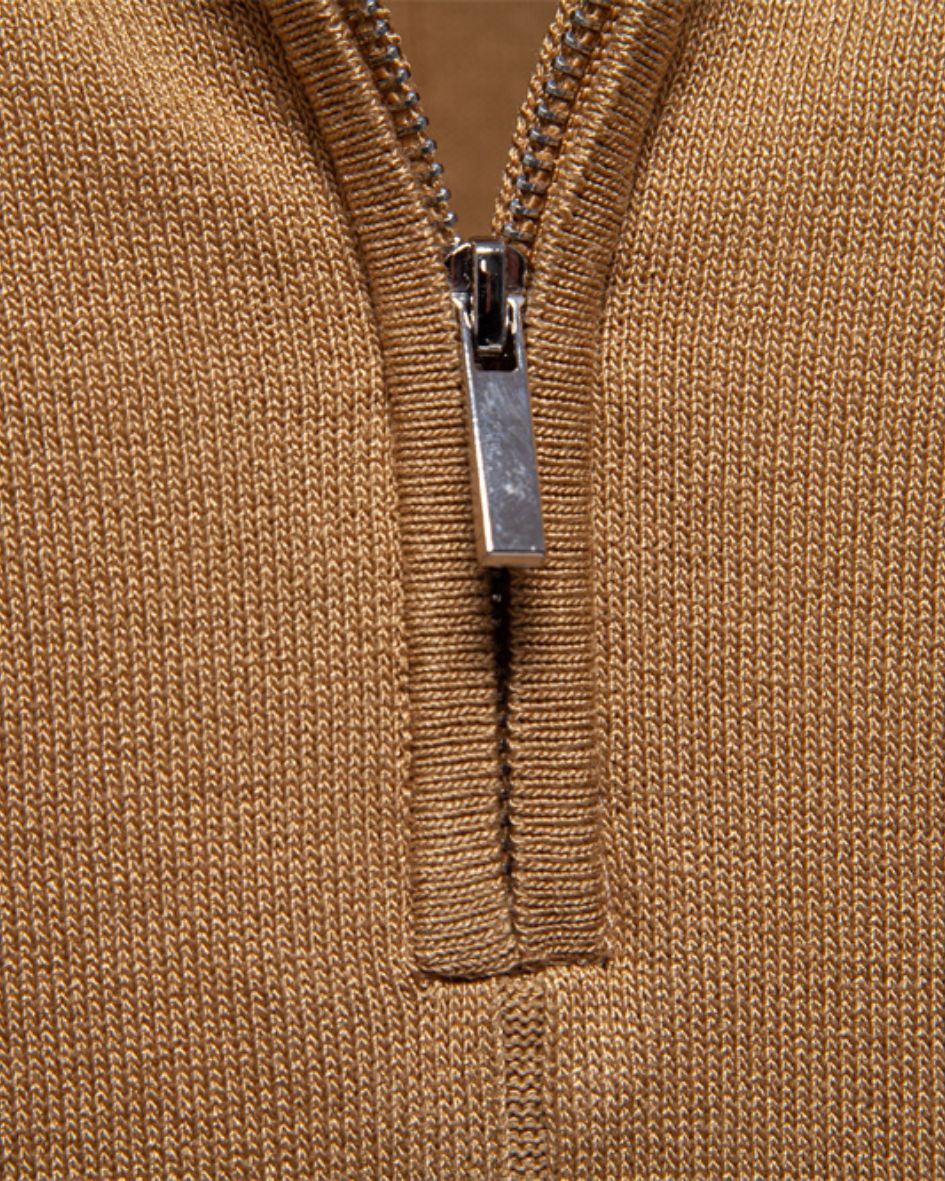 Close-up of a camel zip-up garment with a silver zipper.