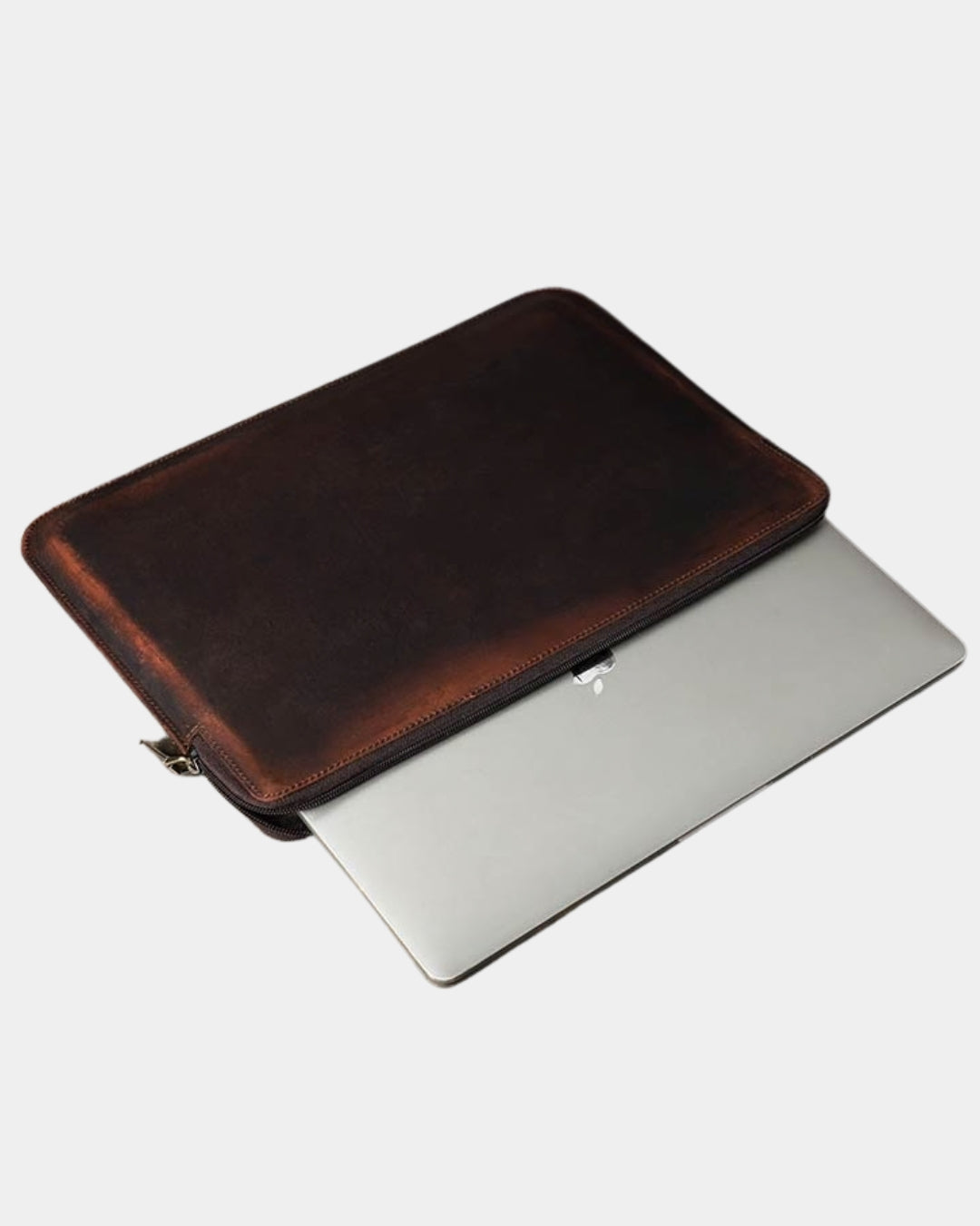 Distressed brown Crazy Horse leather sleeve holding a 14-inch MacBook with a slim, vintage-style design.