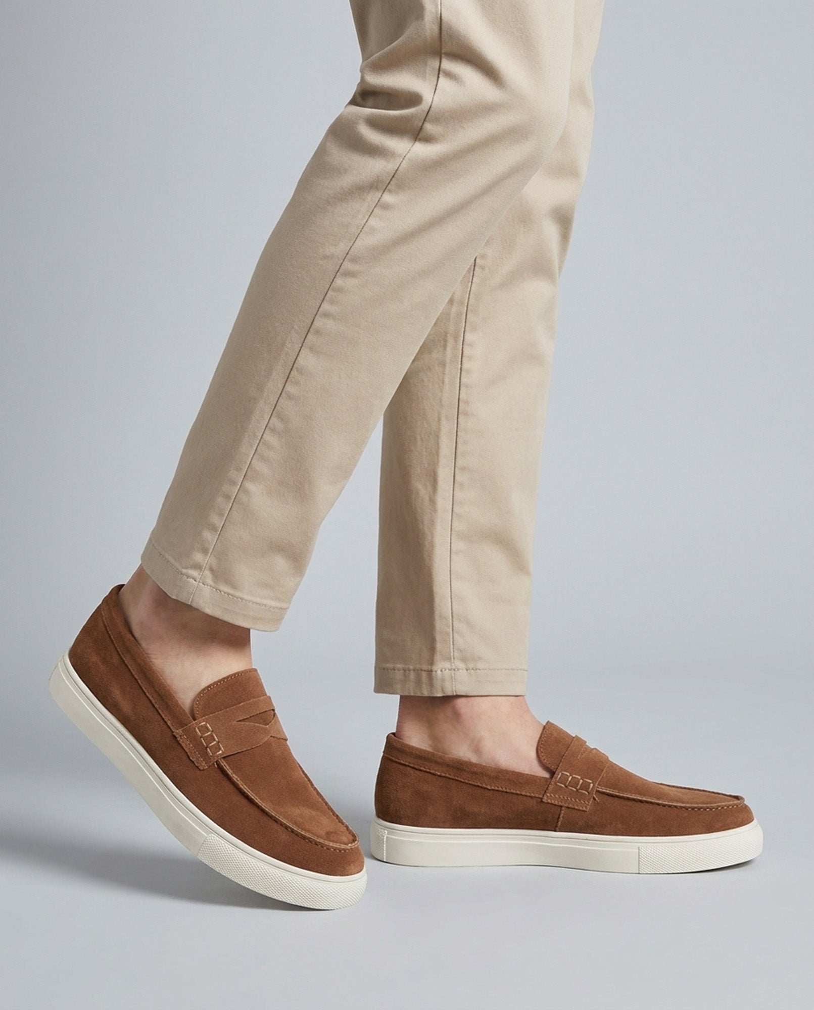 Dunley men's camel penny loafers worn with beige trousers walking