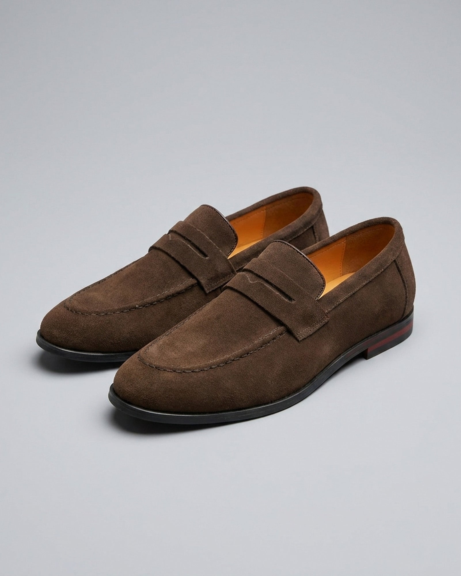 Pair of Harper men's dark brown suede penny loafers with red sole detail