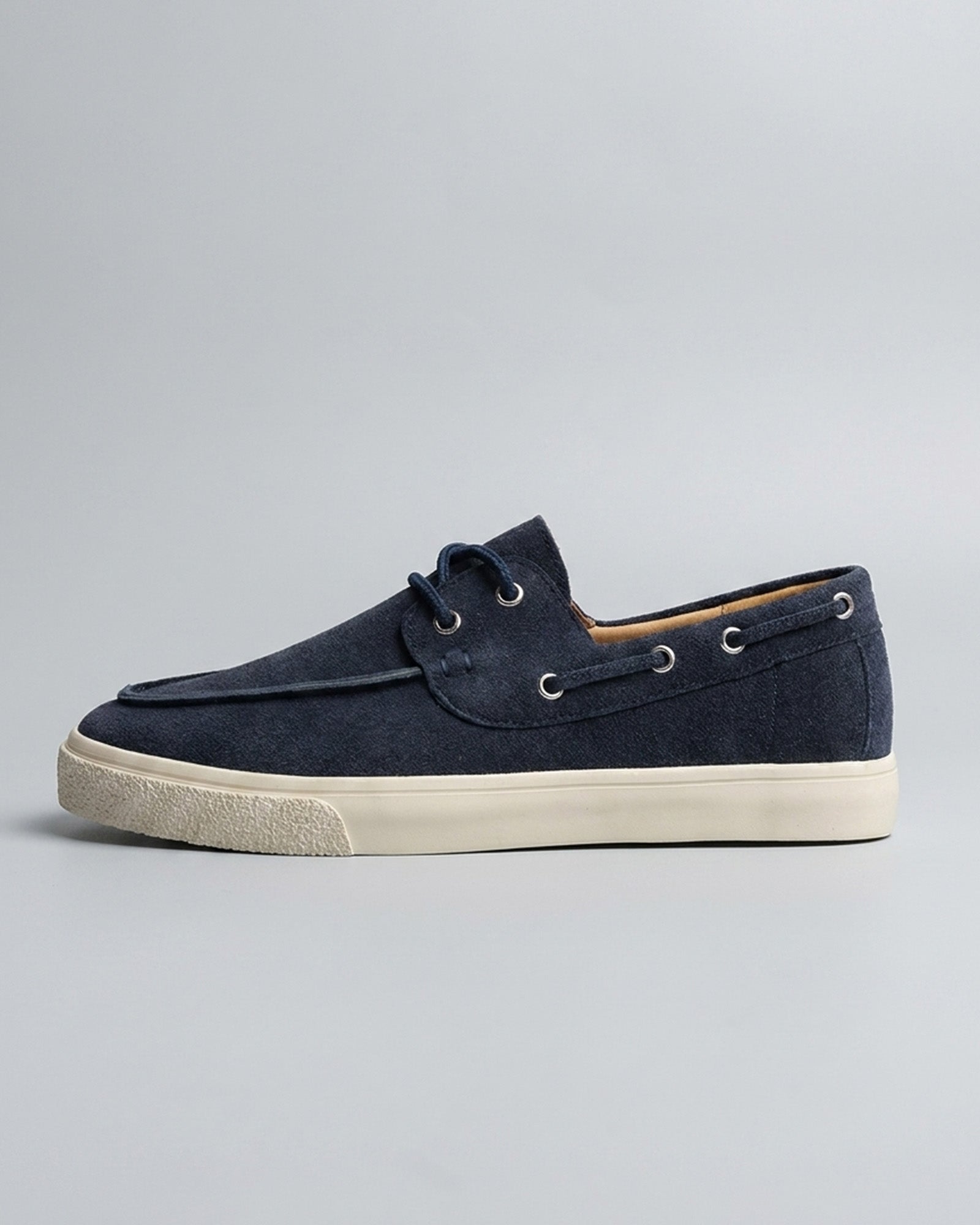 Side view of Harwich men's suede boat shoe sneaker in navy with cream cupsole