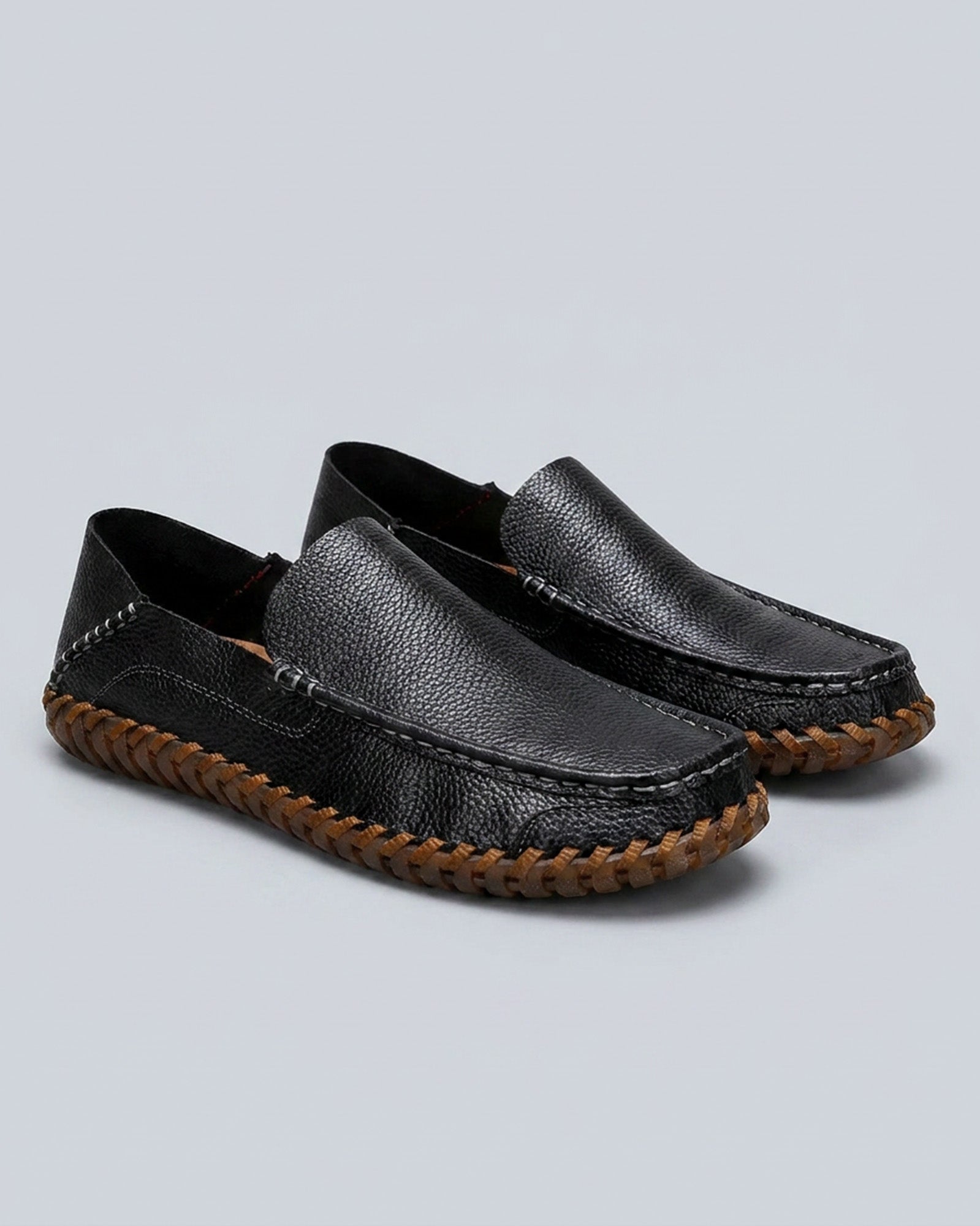 Pair of Marlow men's black leather driving loafers on grey background