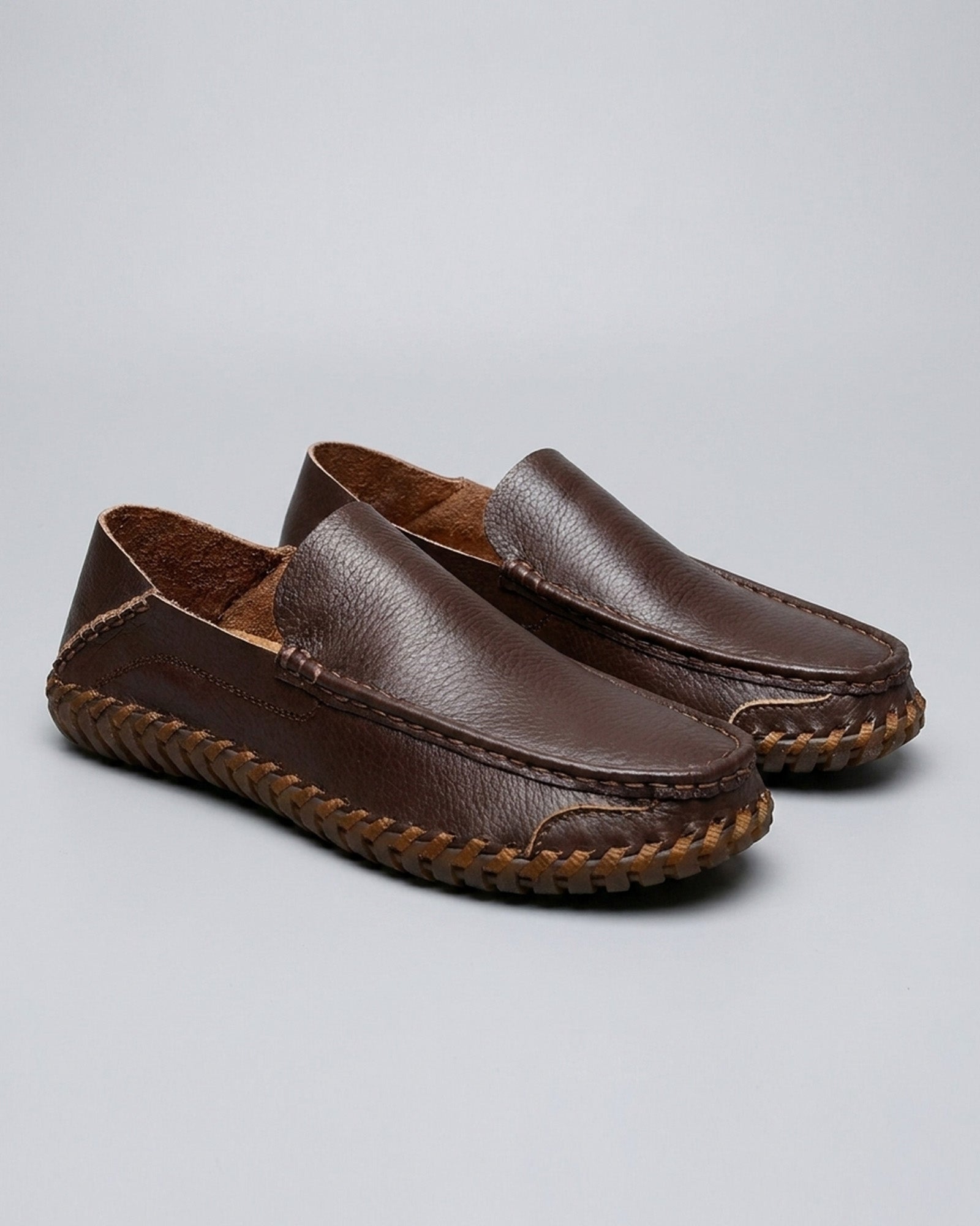 Pair of Marlow men's dark brown leather driving loafers on grey background