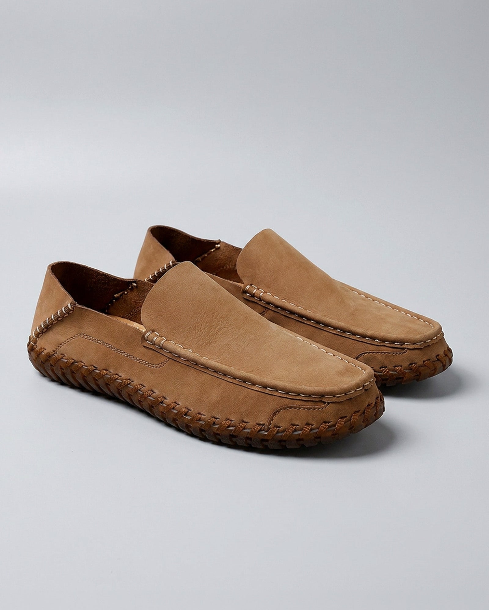 Pair of Marlow men's tan leather driving loafers on grey background