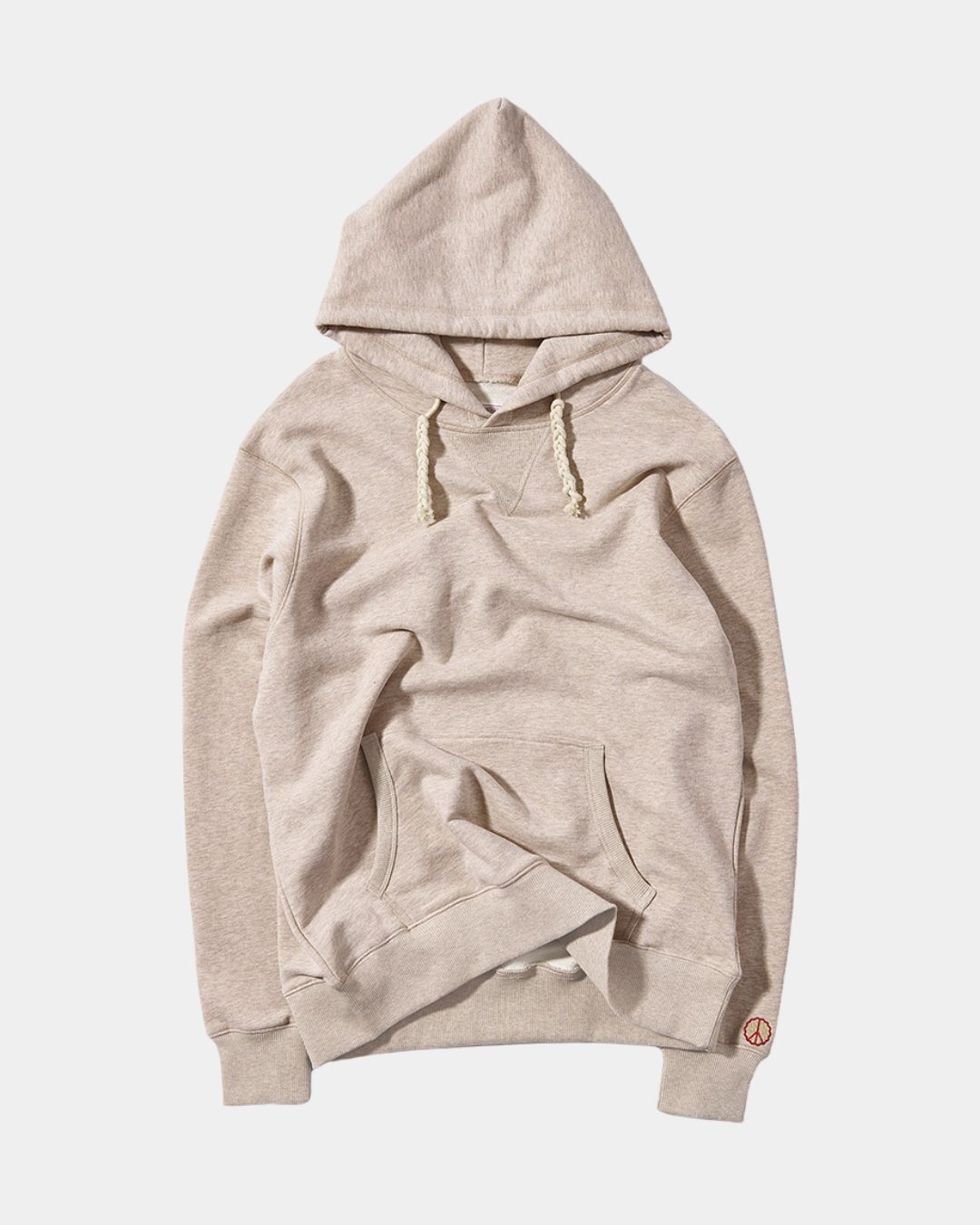 Beige oversized cotton pullover hoodie with a drawstring hood, kangaroo pocket, and small embroidered peace symbol.