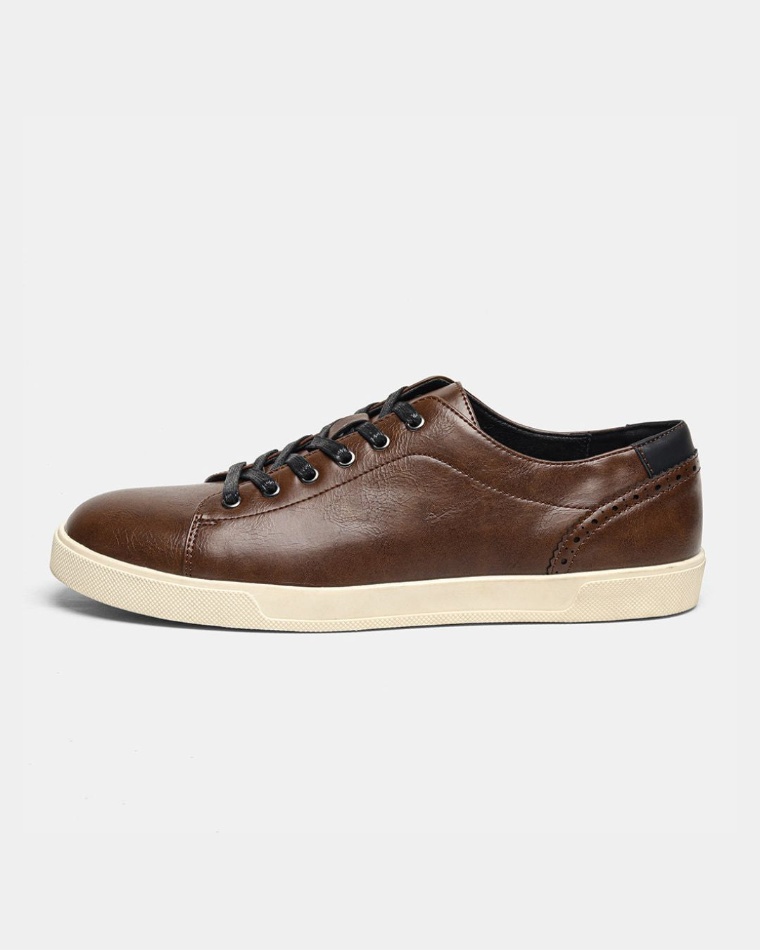 Brown low-top dress sneaker with faux leather upper, black heel tab, brogue detailing, and a cream rubber sole.