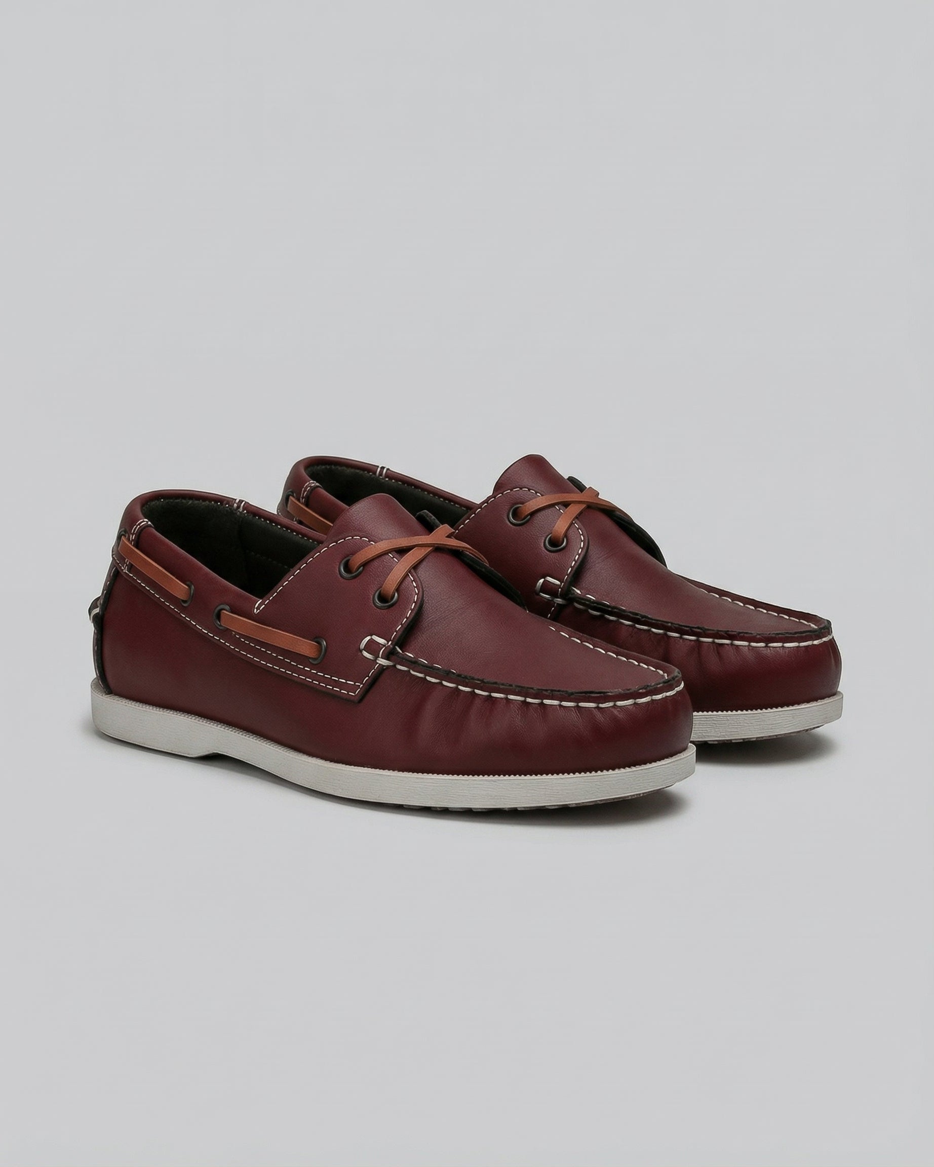 Men's burgundy lace-up boat shoes with white contrast moccasin stitching and tan side trim – front view