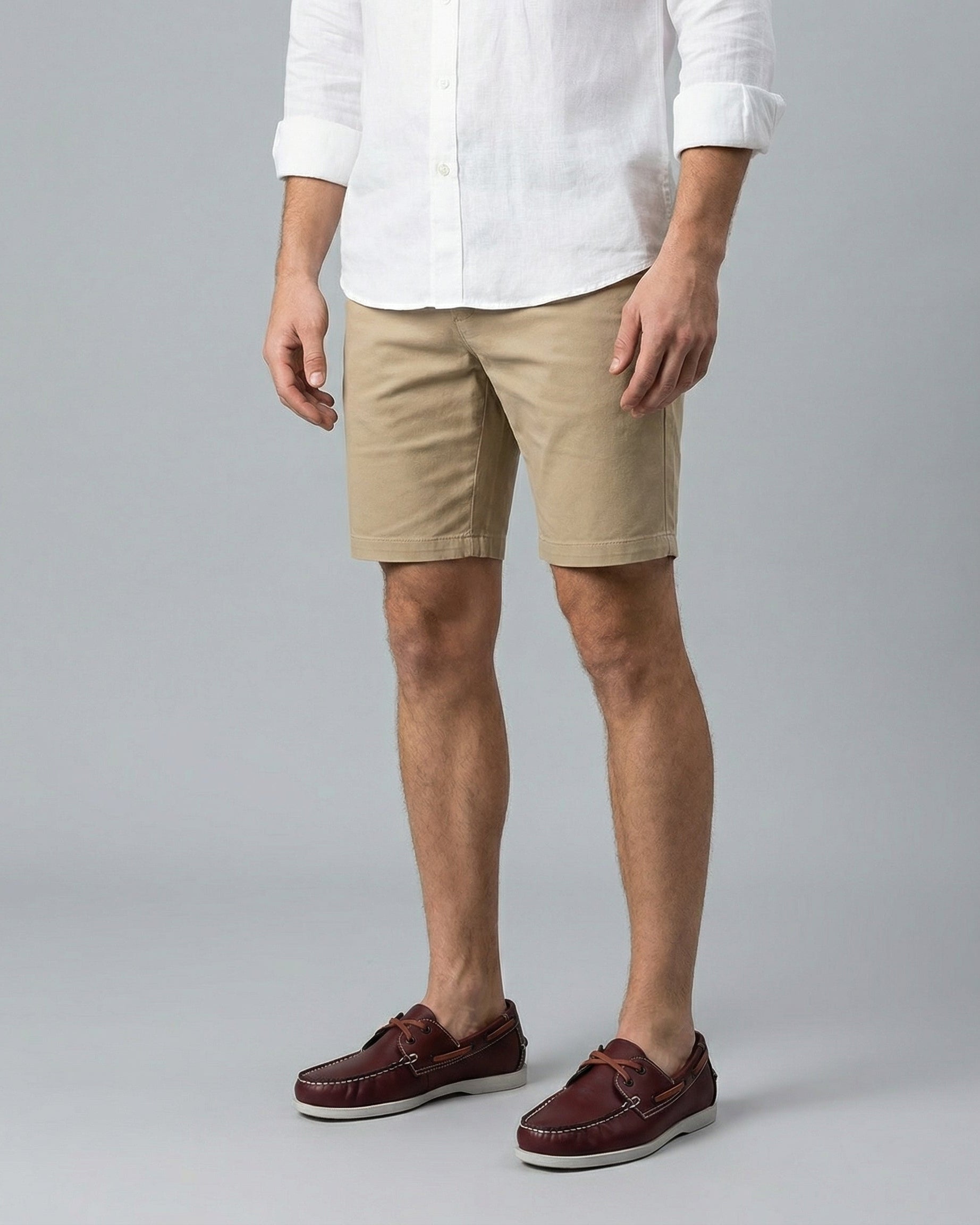 Men's burgundy faux leather boat shoes with white sole worn with chino shorts and white linen shirt