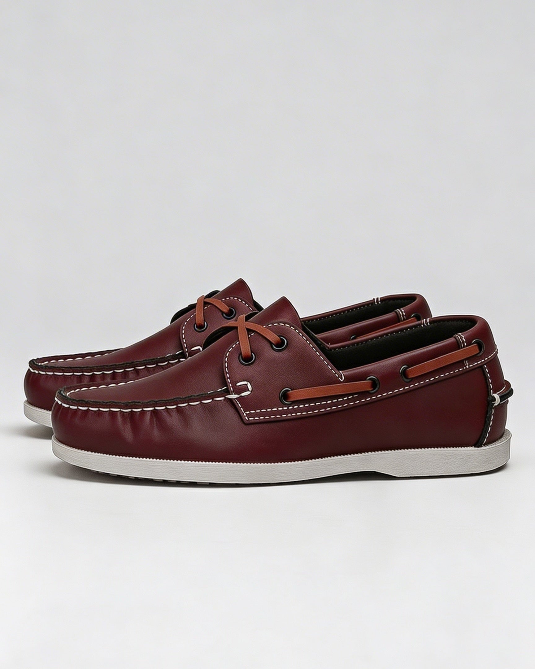 Men's burgundy faux leather boat shoes with tan trim, dark eyelets and white rubber sole – side view