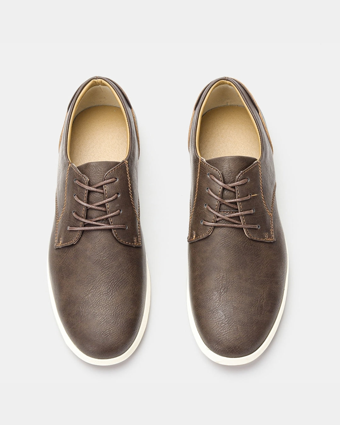 Brown synthetic leather lace-up dress sneakers with a white rubber sole, viewed from above against a light background.