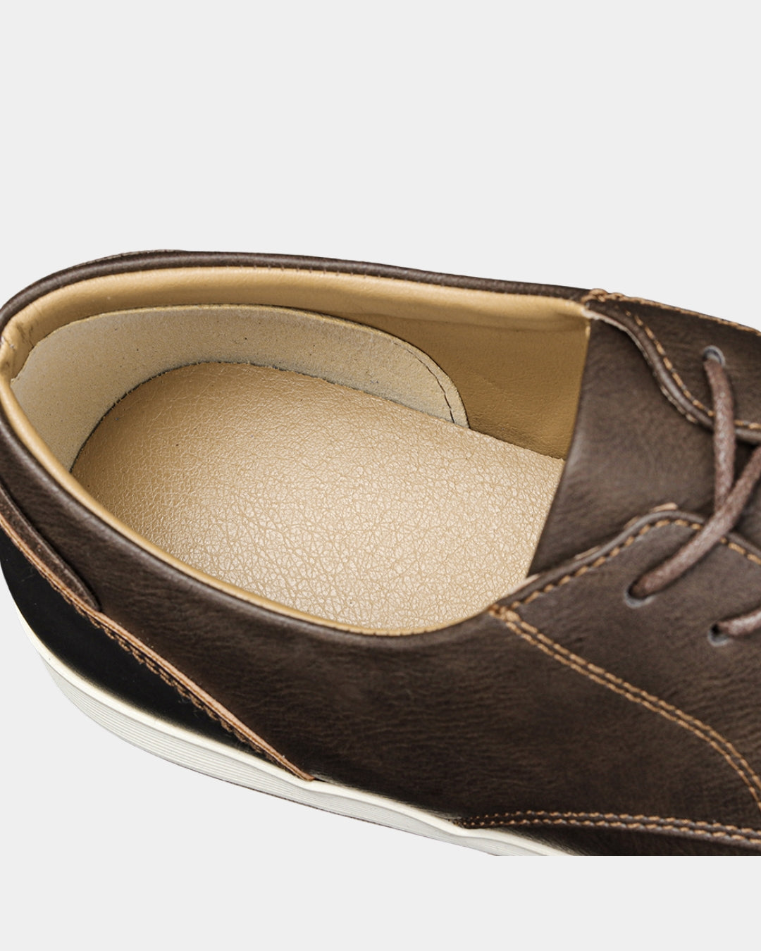 Close-up of a brown synthetic leather casual dress sneaker featuring a cushioned tan insole and classic lace-up design.