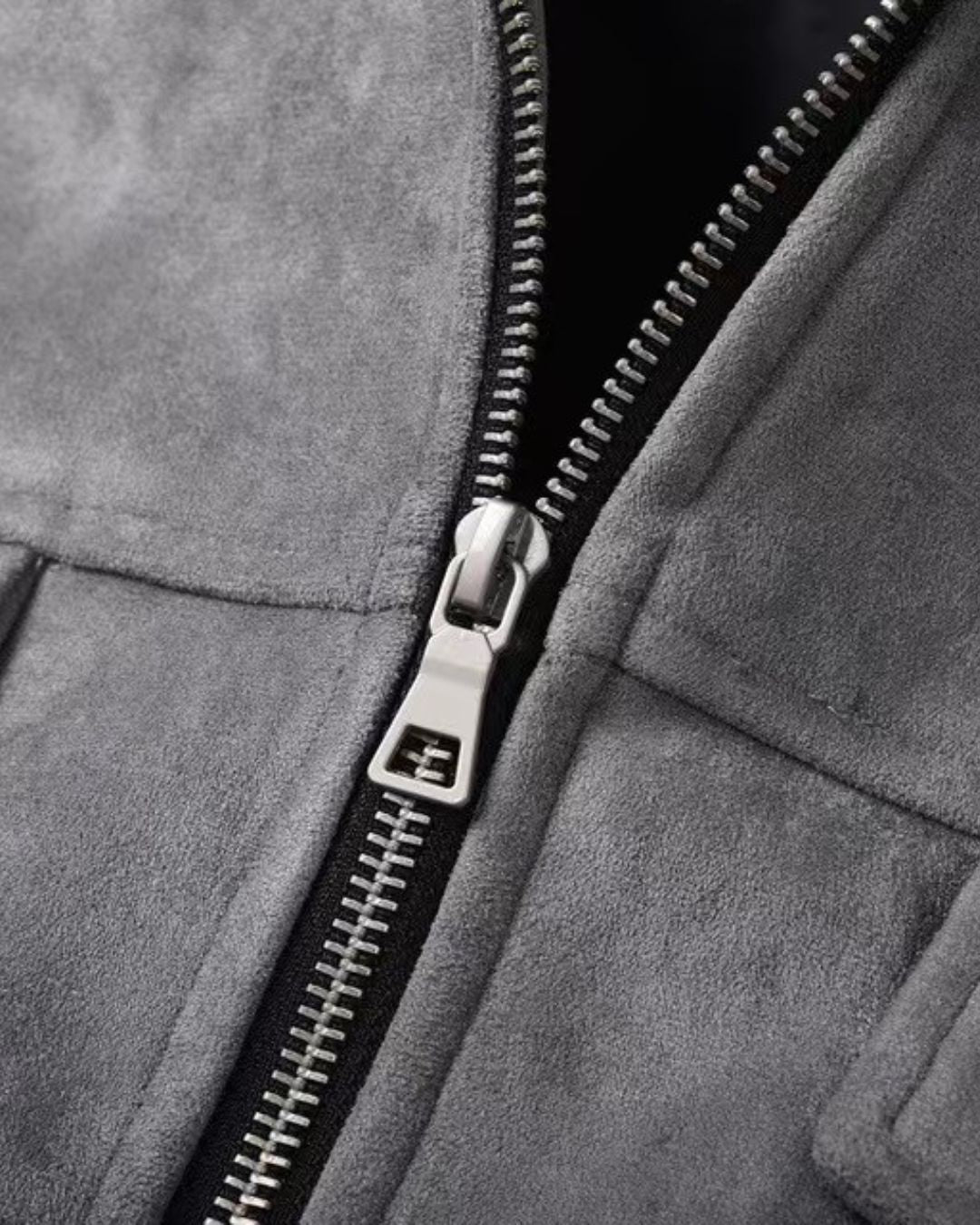 Close-up of a men's gray casual zip-up overshirt jacket with a black zipper and a silver metal pull tab