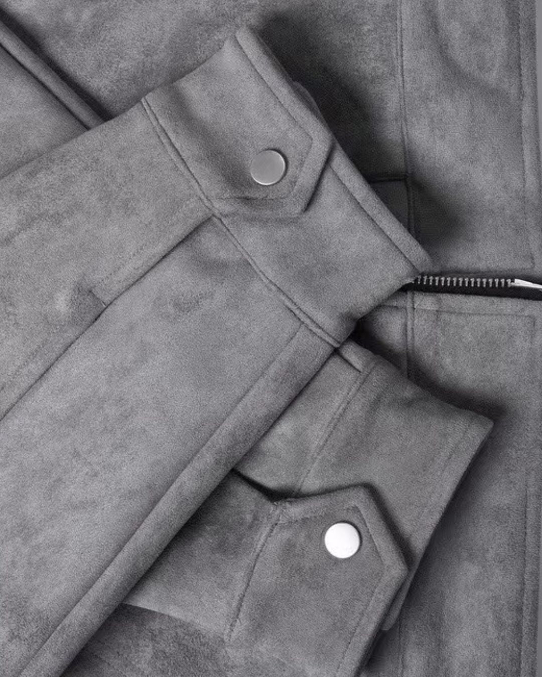 Close-up of a men's gray casual zip-up overshirt jacket showing the collar, sleeve cuff with snap button, and zipper detail.