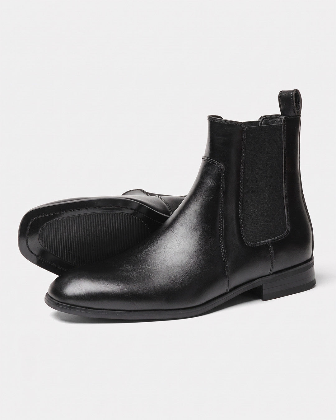Men’s black Chelsea dress boots with a smooth finish, square-toe silhouette, elastic side panels, and rubber outsoles.