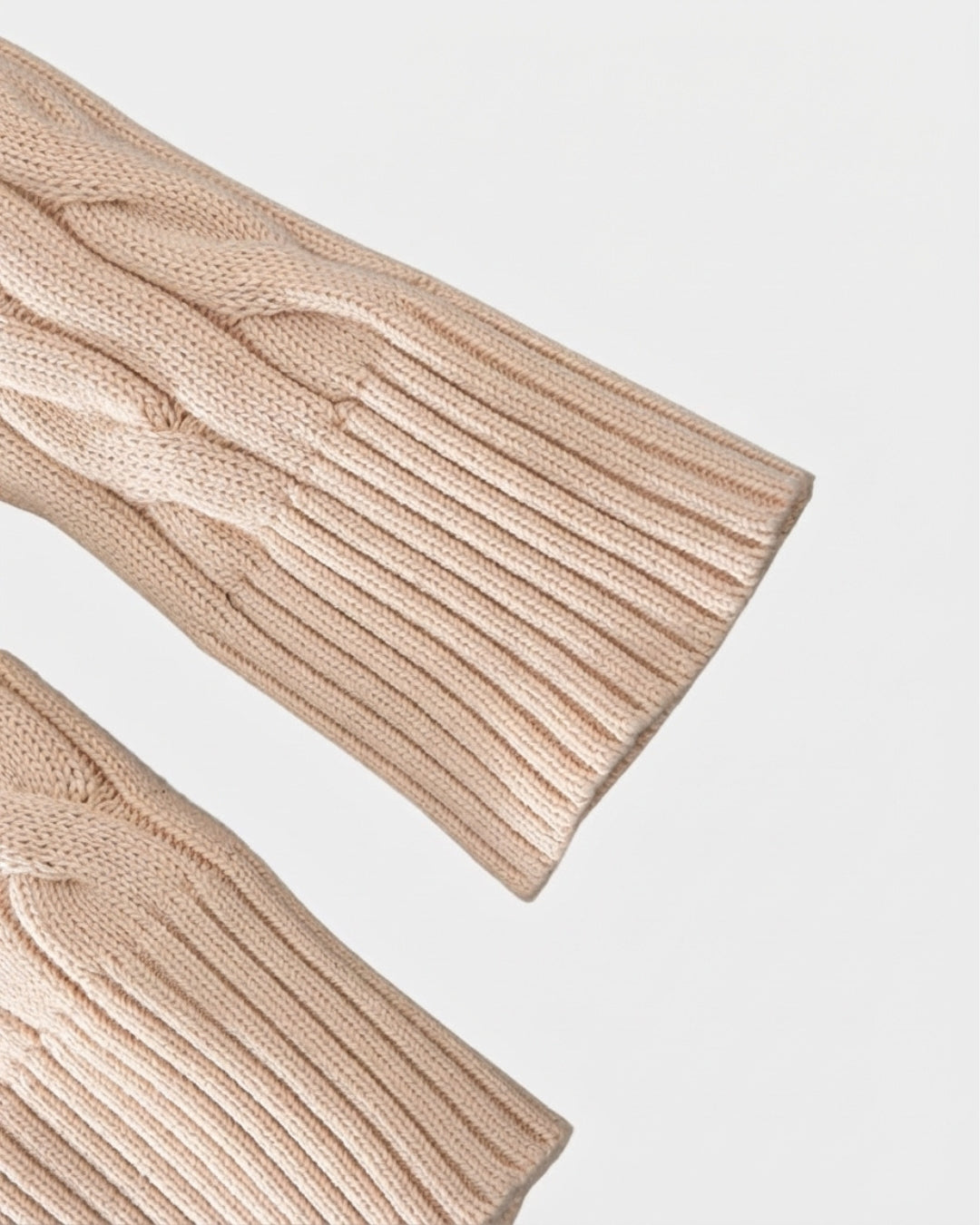 Beige cotton cable knit sweater sleeves featuring ribbed cuffs and textured detailing.