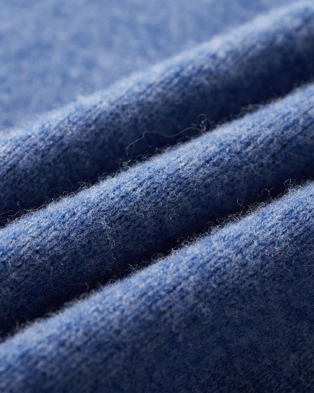 Close-up of a soft, blue 100% wool knit fabric with a smooth texture and subtle ribbed detail.