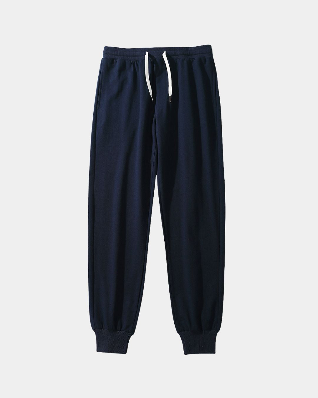 Navy blue cotton jogger sweatpants with a white drawstring waist and ribbed tapered ankle cuffs.