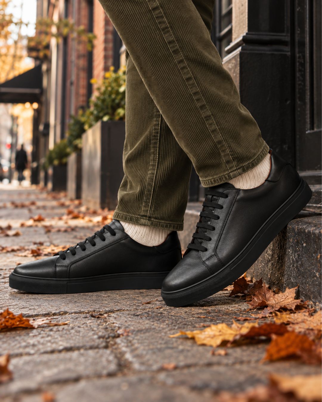 Men’s black genuine leather low-top dress sneakers with a minimalist lace-up design and durable rubber outsole.