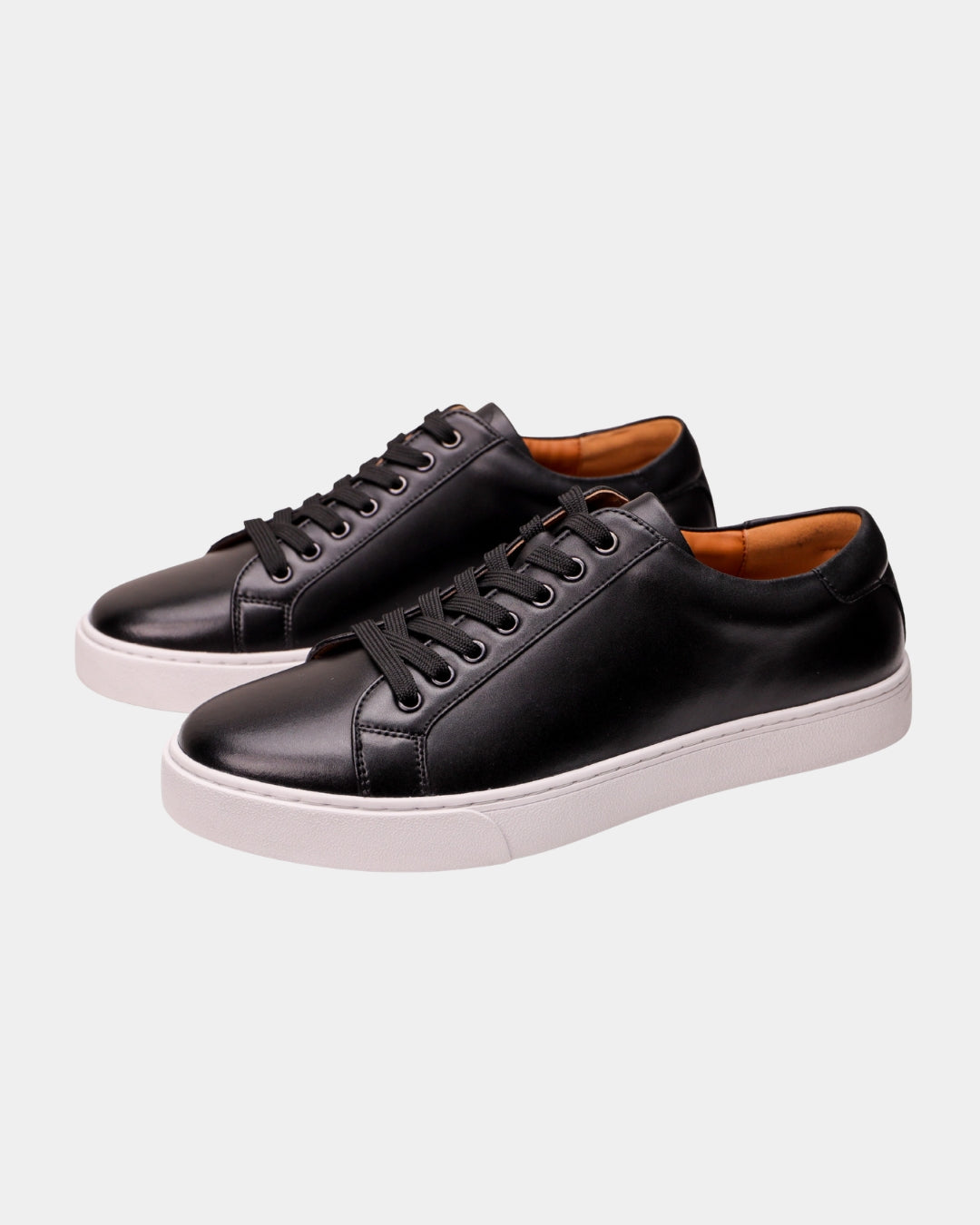 Men's black genuine leather low-top dress sneakers with black laces and a clean white rubber outsole.