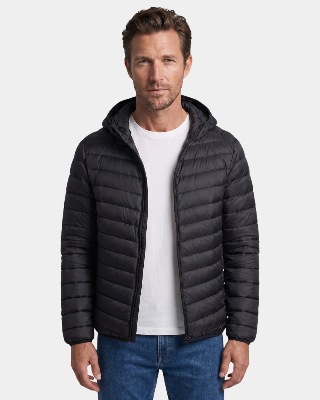 Man wearing a black, lightweight hooded puffer jacket with a quilted design and full-zip front.