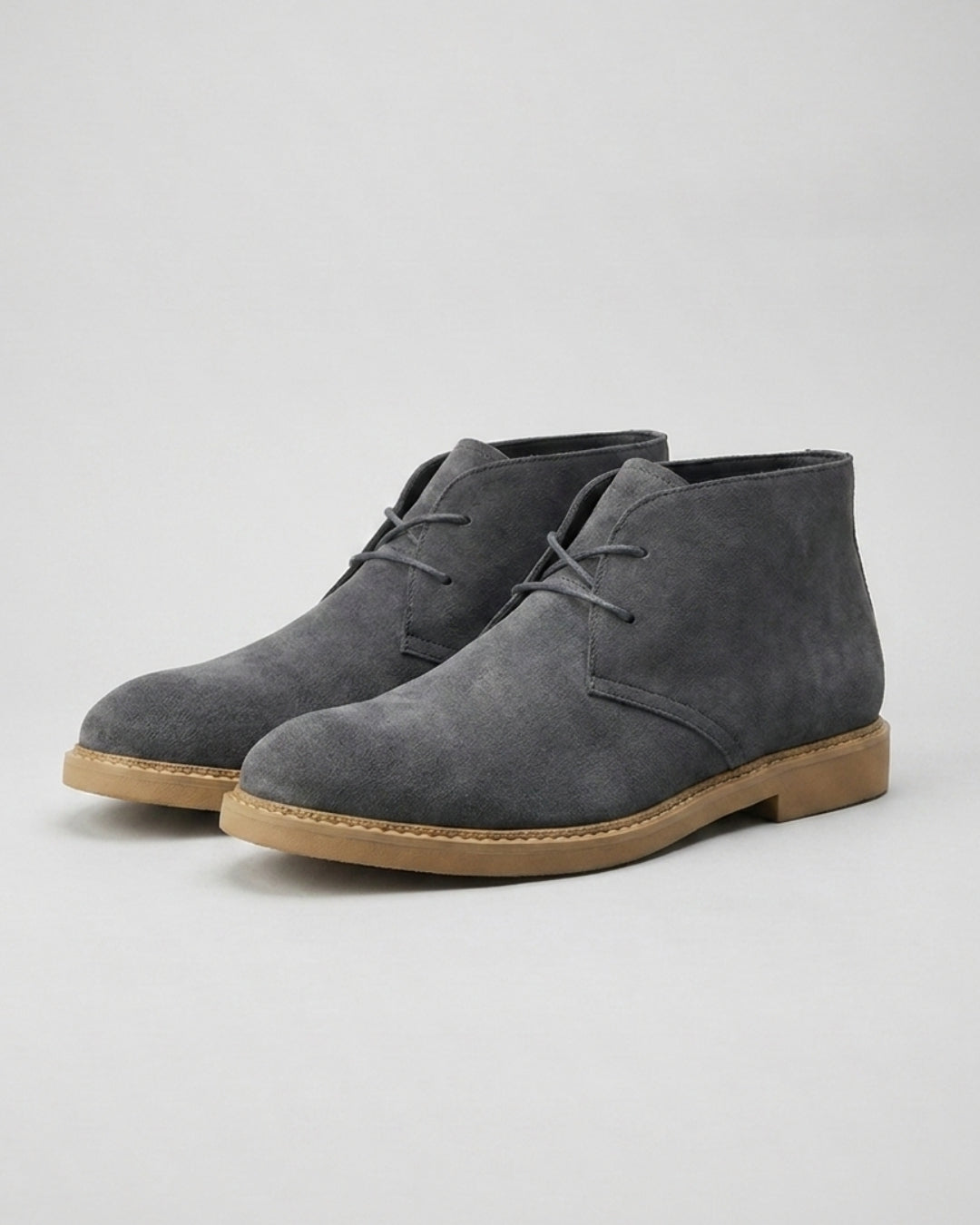 Gray suede men’s chukka boots with a two-eyelet lace-up design, square toe, and durable flat rubber sole.