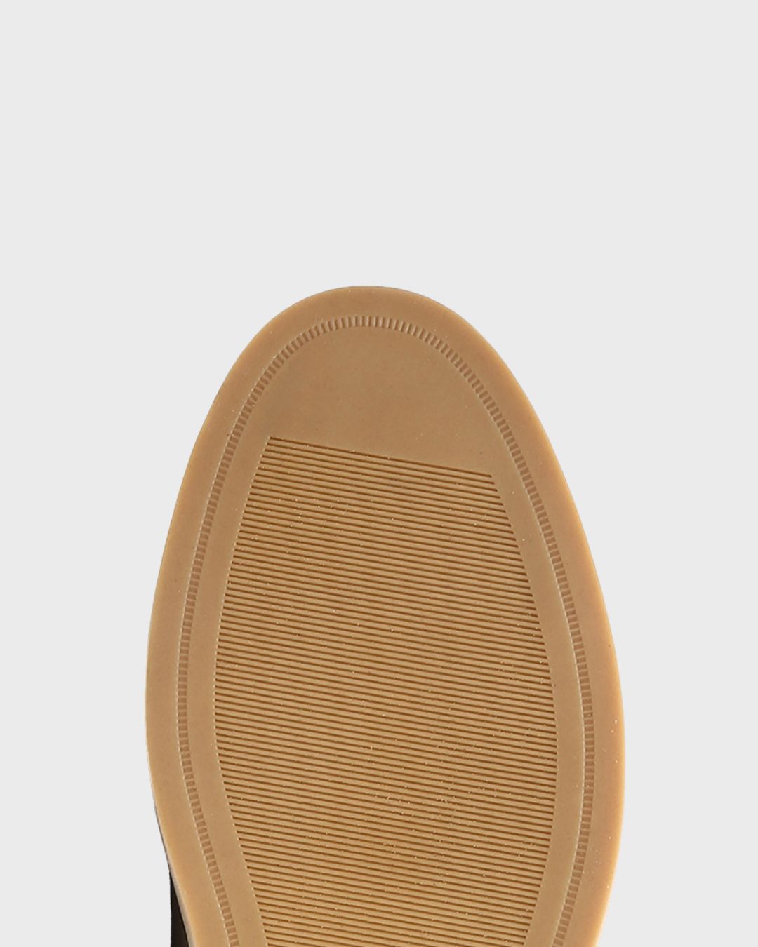 Close-up of a tan rubber shoe sole of a men's chukka boot.