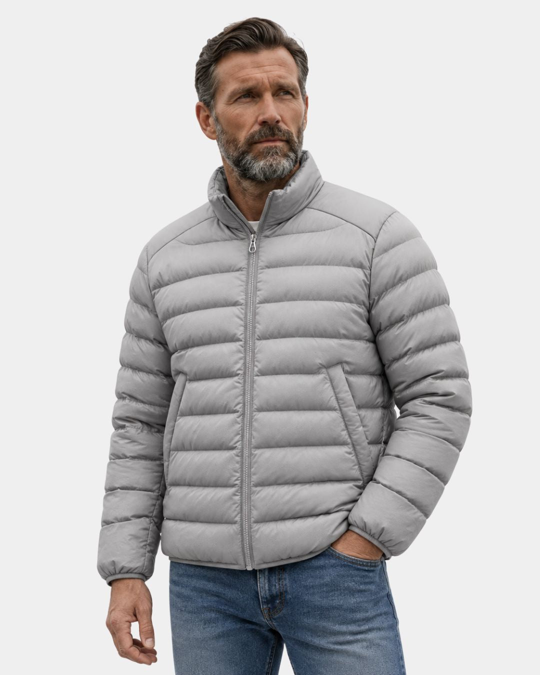 Man wearing a light grey, quilted duck down puffer jacket with a stand collar and full-zip front.