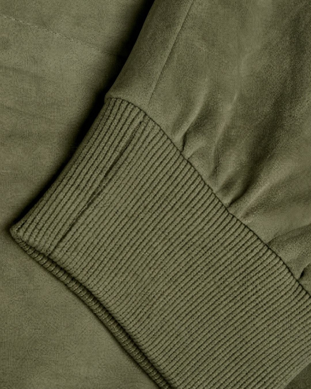 Olive green lightweight fleece bomber jacket sleeve with a soft, suede-inspired finish and ribbed cuff detail.