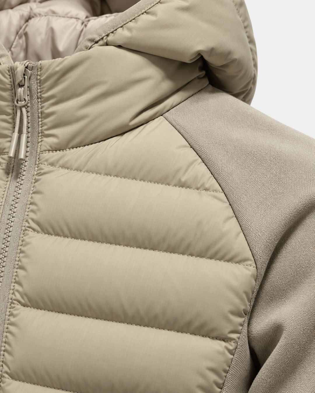 Beige hooded hybrid puffer jacket with quilted front panels, smooth sleeves, and a full-zip closure.
