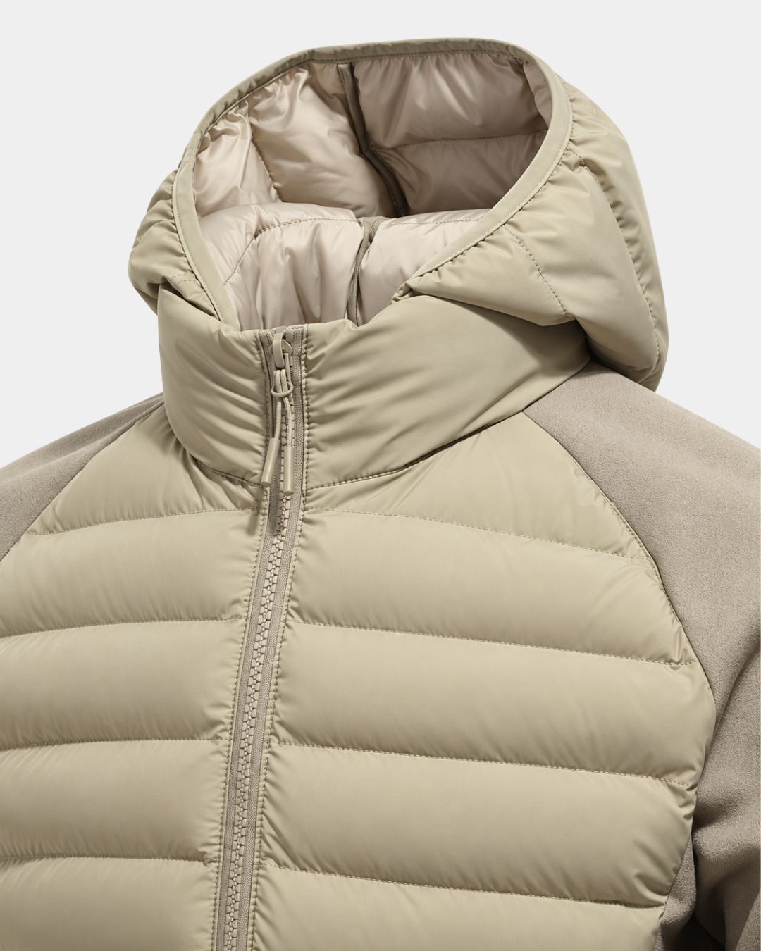 Beige hooded puffer jacket with quilted front panels, full-zip closure, and smooth contrasting sleeves.