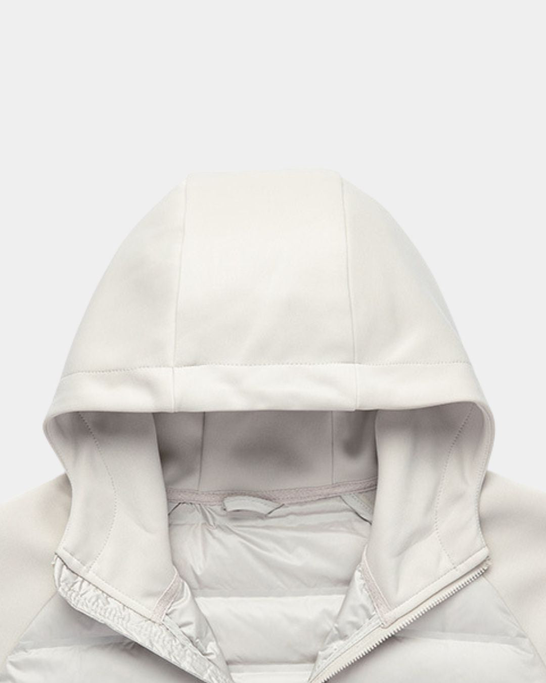 Lightweight beige hybrid puffer jacket with a soft knit hood and quilted down-filled body.