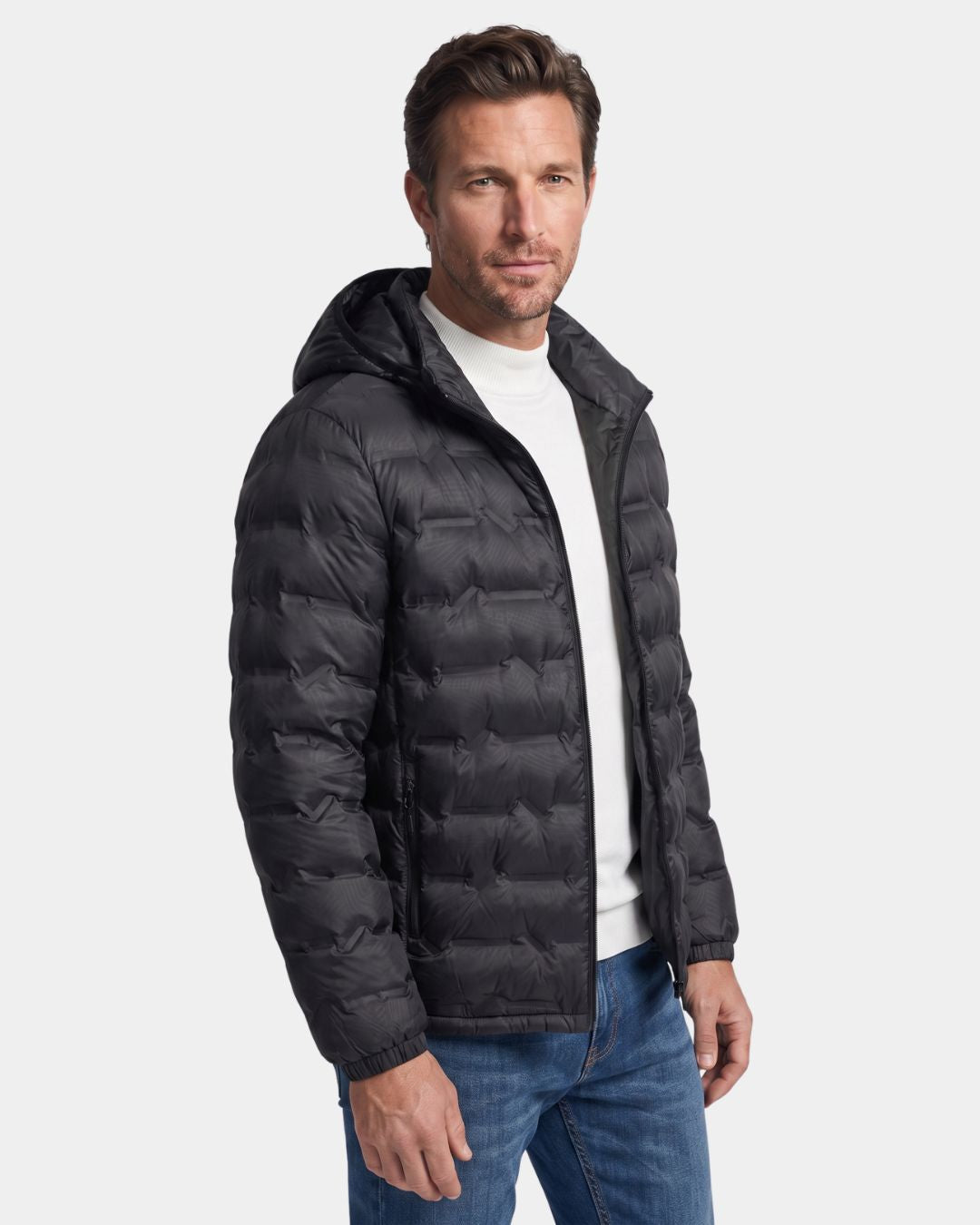 Man wearing a black lightweight quilted down puffer jacket with a detachable hood and full-zip front.