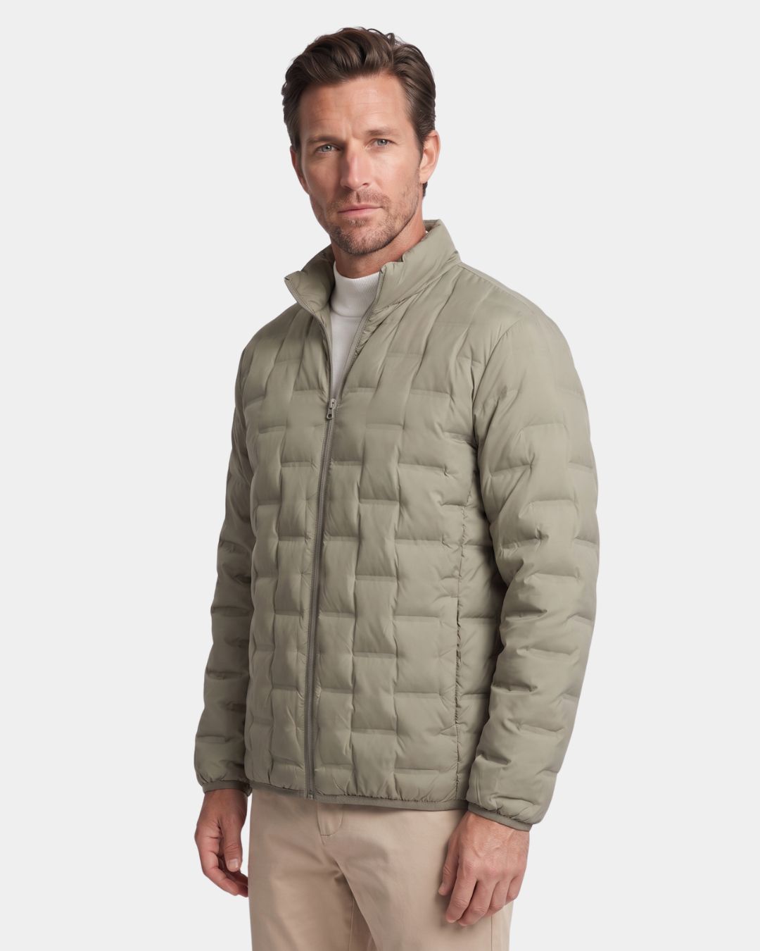 Man wearing a sage green lightweight down puffer jacket with a stand collar, quilted construction, and full-zip front.
