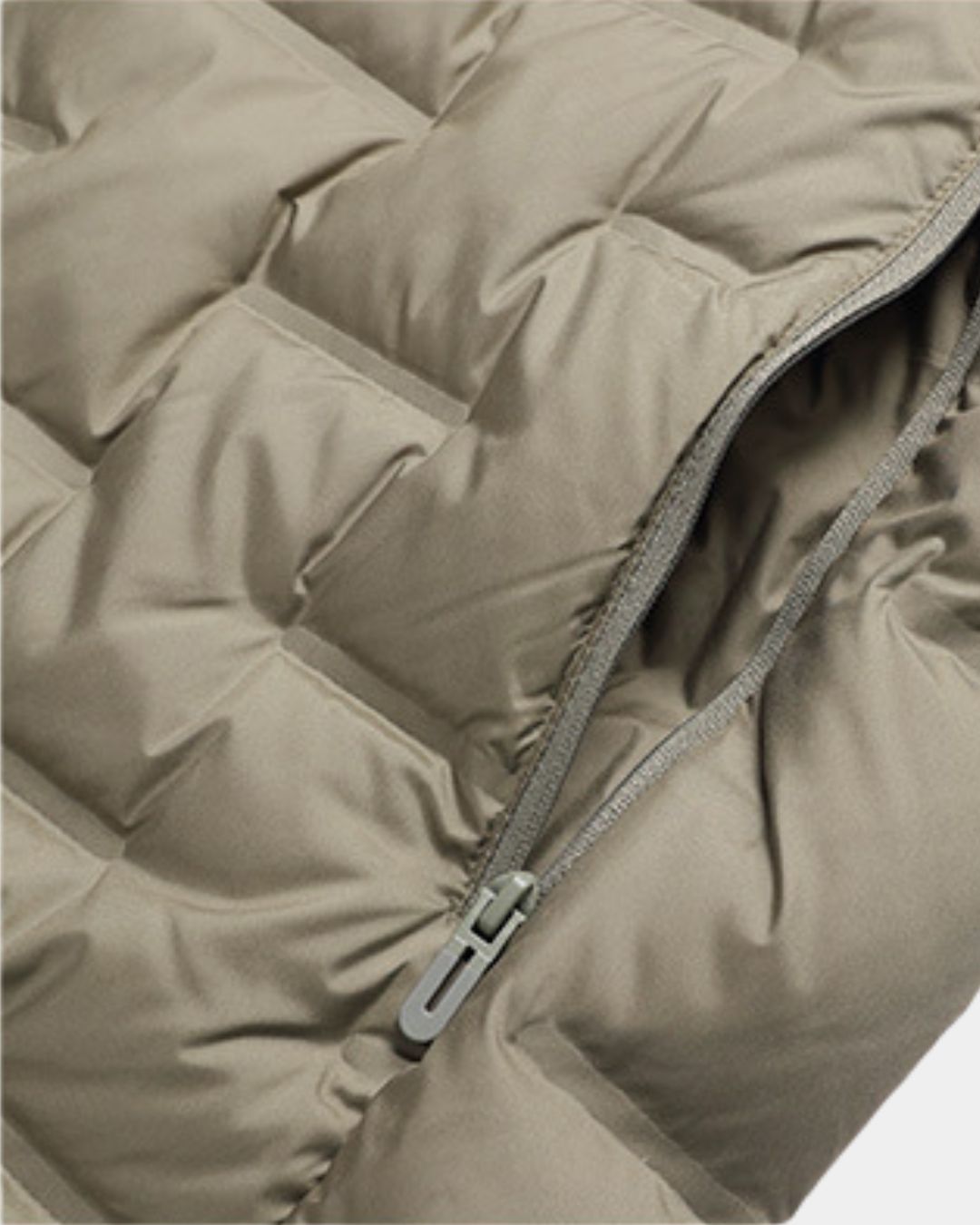 Close-up of a taupe quilted down puffer jacket featuring a smooth fabric texture and a matching zippered pocket.