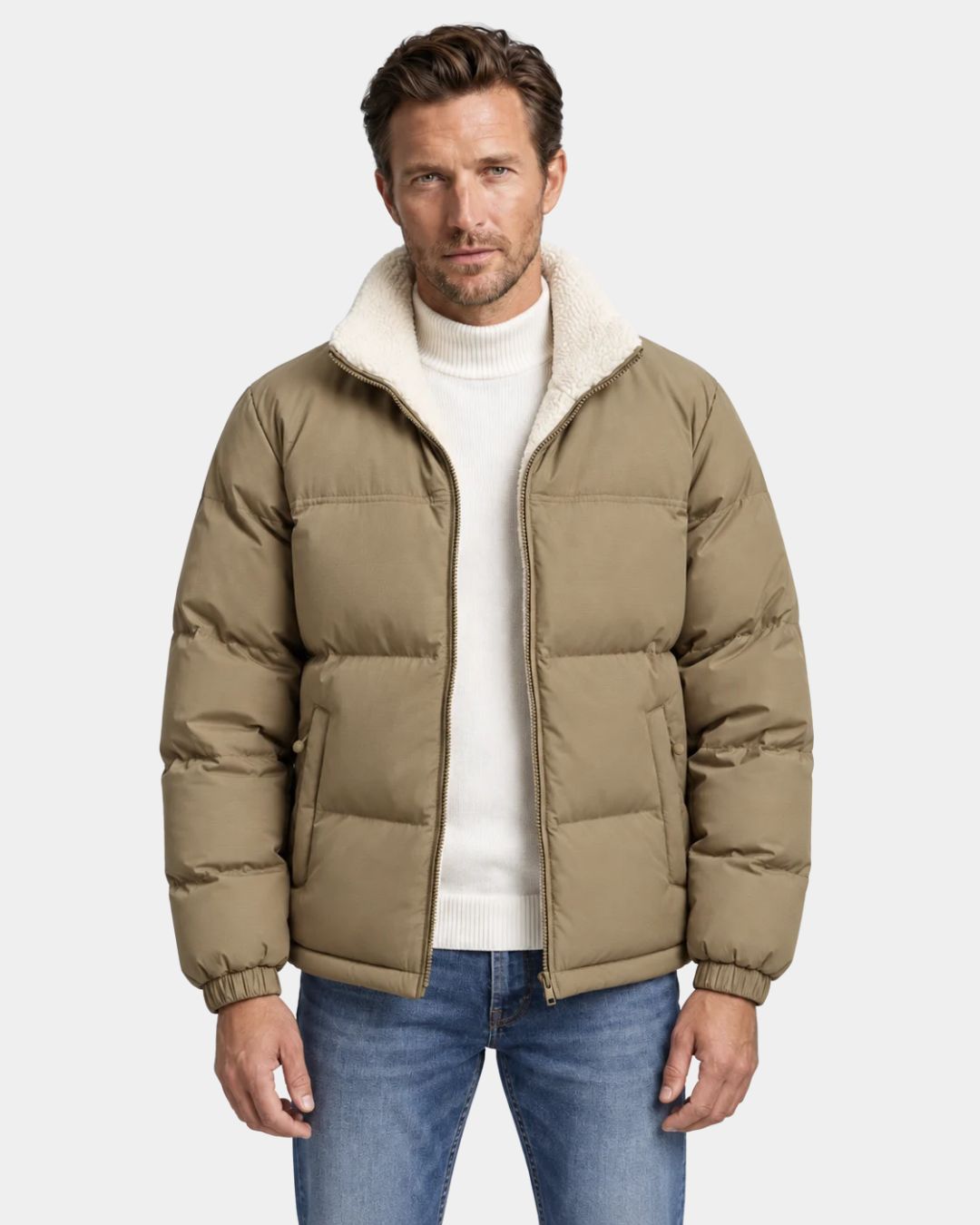 Man wearing a tan reversible puffer jacket with a cream fleece-lined stand collar and full-zip front.