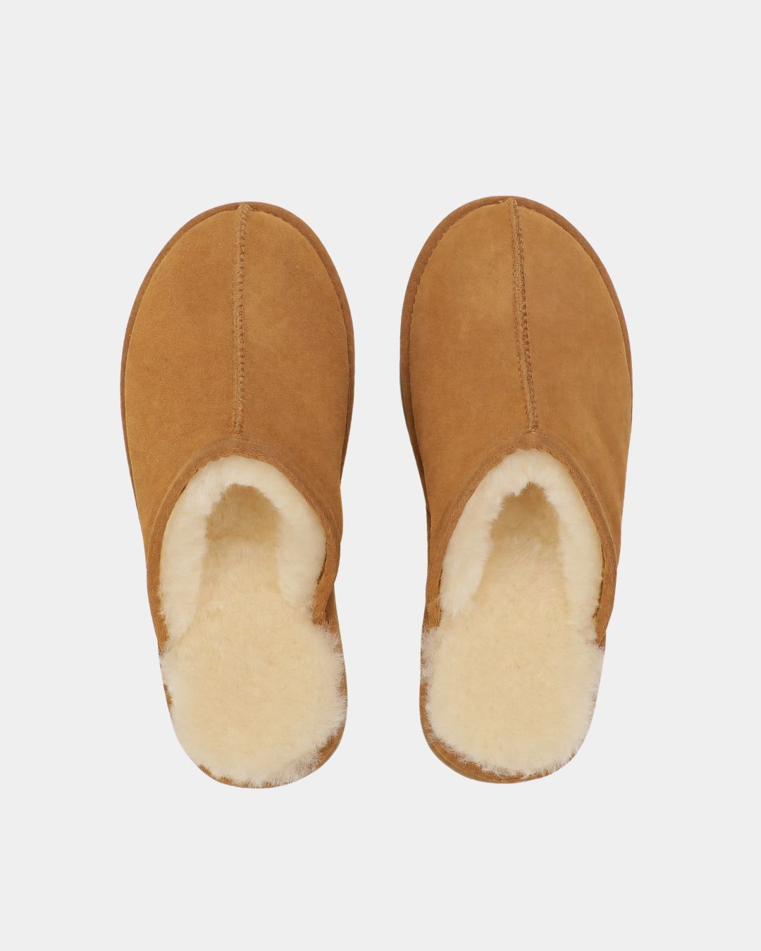 Tan sheepskin mule slippers for men with a soft, cream-colored wool lining and a durable rubber sole.