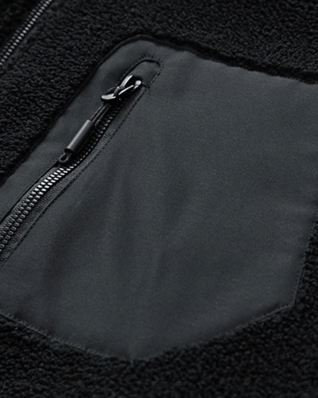 Black men’s sherpa fleece utility jacket featuring a textured teddy finish and a contrasting zippered chest pocket.