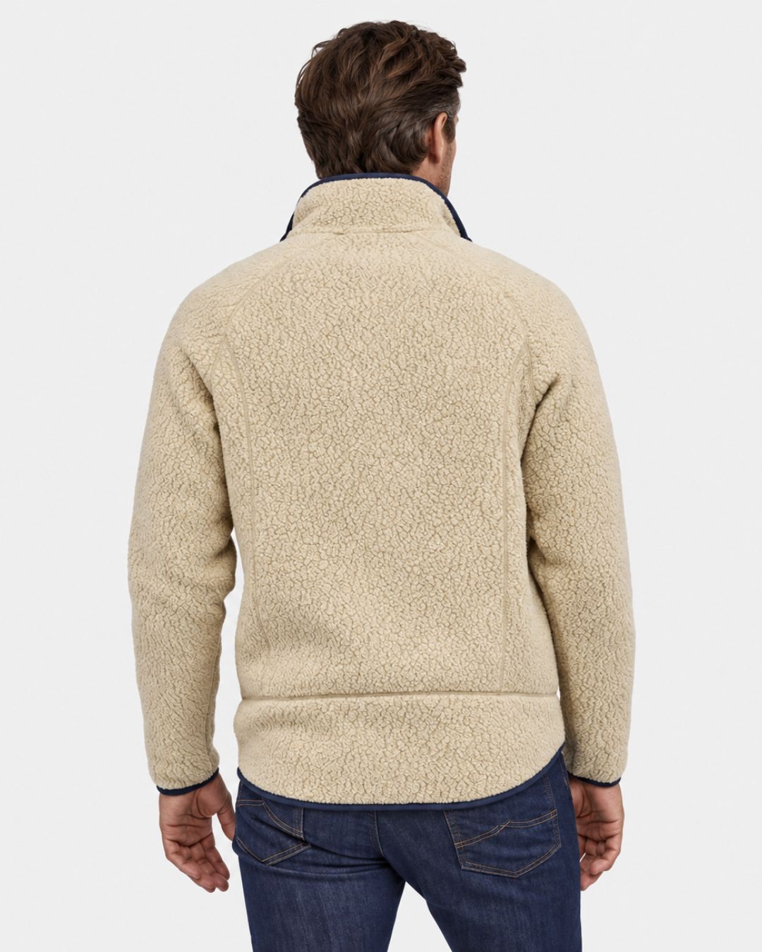 Back view of a men’s beige teddy sherpa fleece jacket with a stand collar and navy blue trim, worn with dark denim jeans.