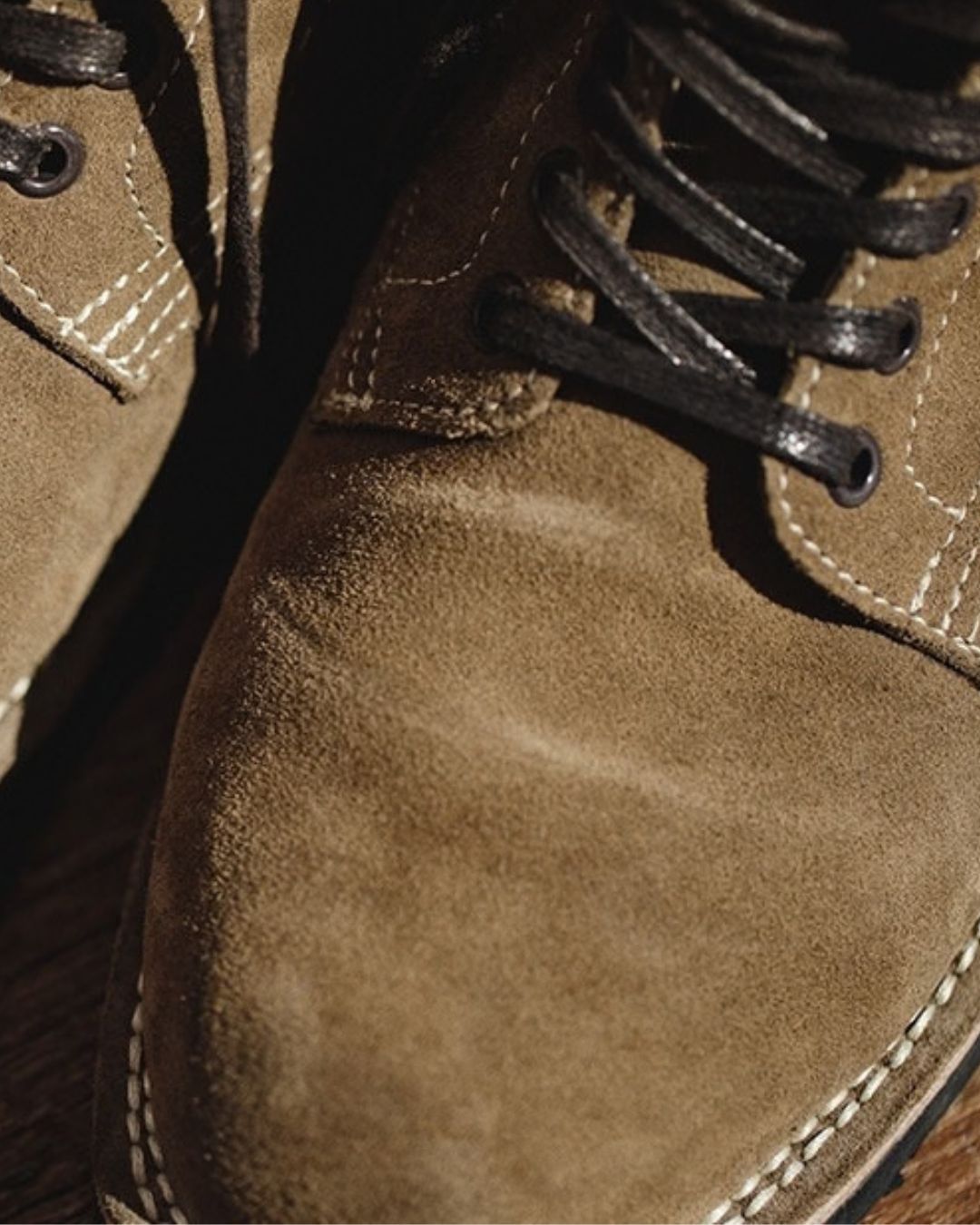 Tan cow suede ankle boots with round toes, contrast stitching, and dark brown lace-up closures.