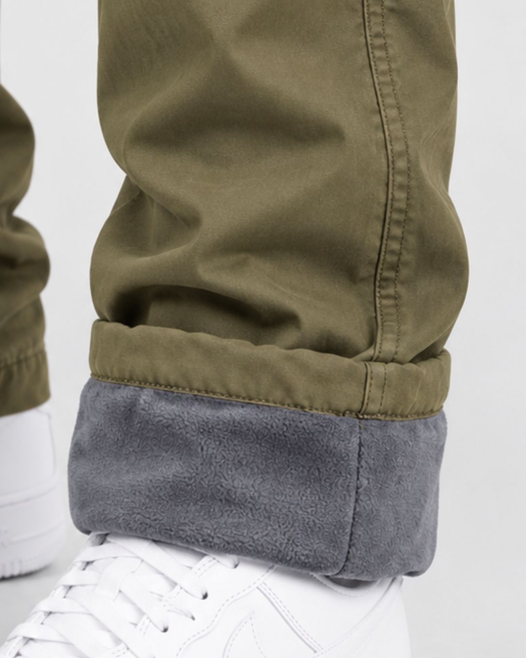 Olive green cargo pants with a thick, gray fleece lining visible at the cuffed hem.