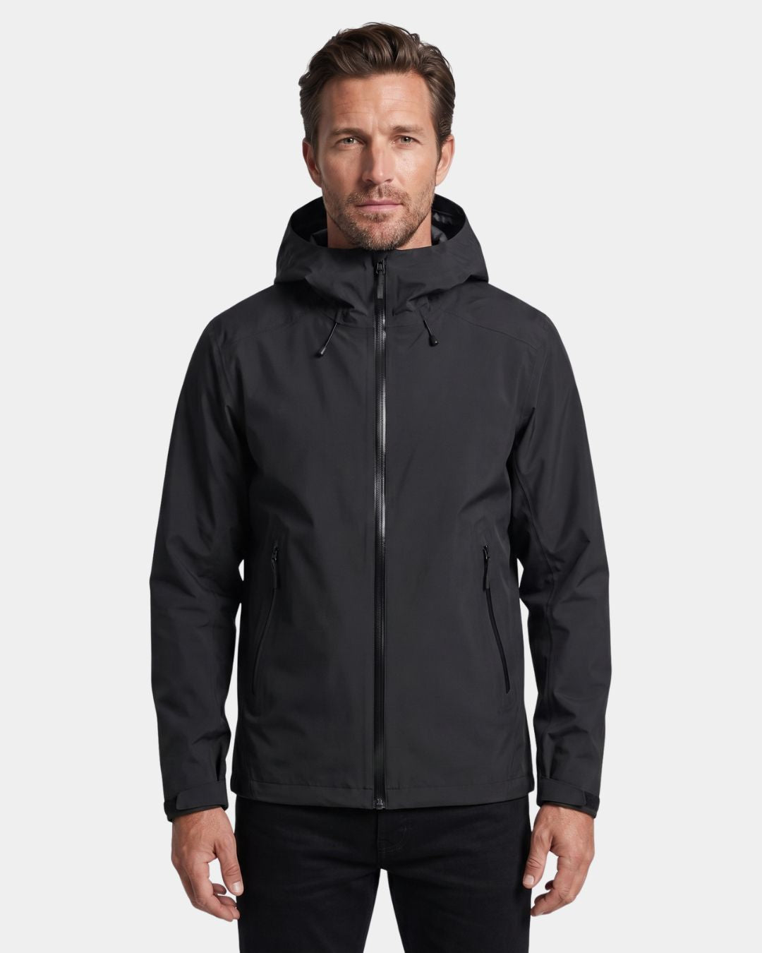 Man wearing a black waterproof hooded hiking windbreaker with a full-zip front and adjustable features.