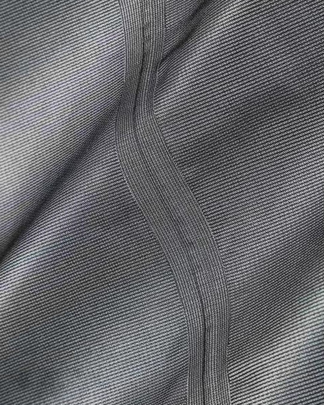 Close-up of a charcoal grey waterproof hiking jacket featuring durable taped seams for weather protection.